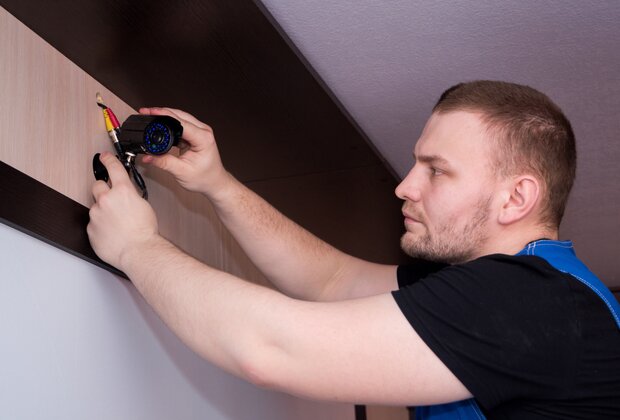 Security installer working on a surveillance camera